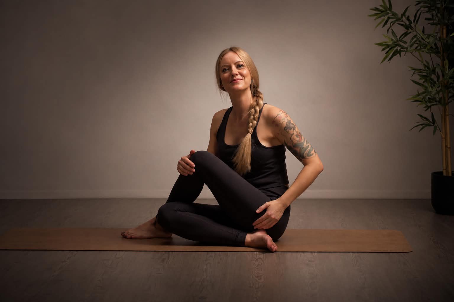 Mia sittende i yogastilling, smilende